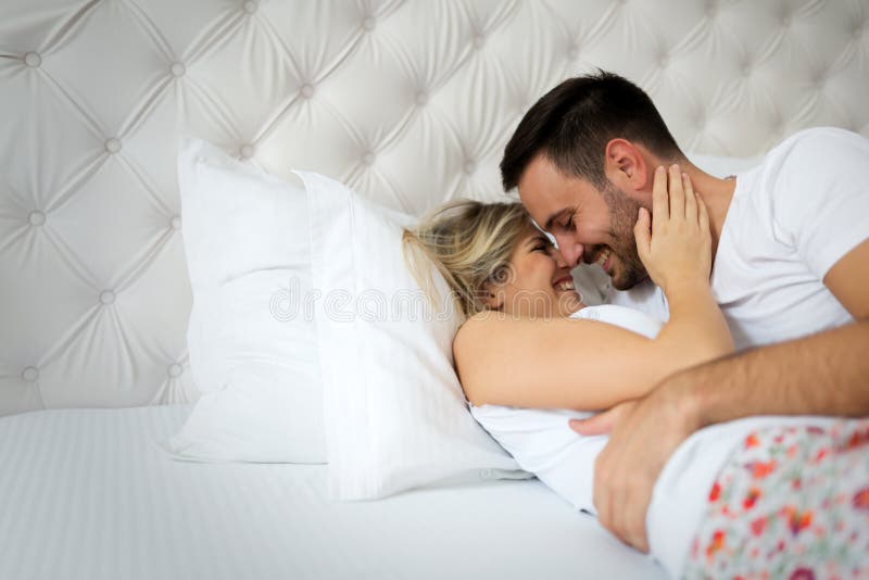 Man and woman kissing in bed
