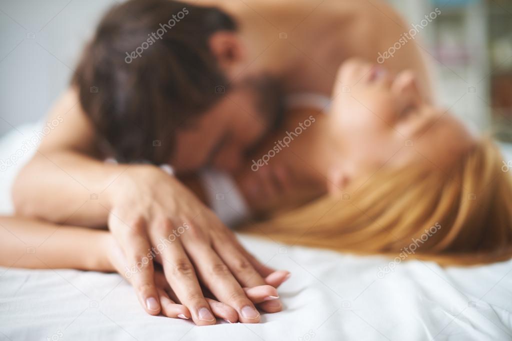 Man and woman kissing in bed