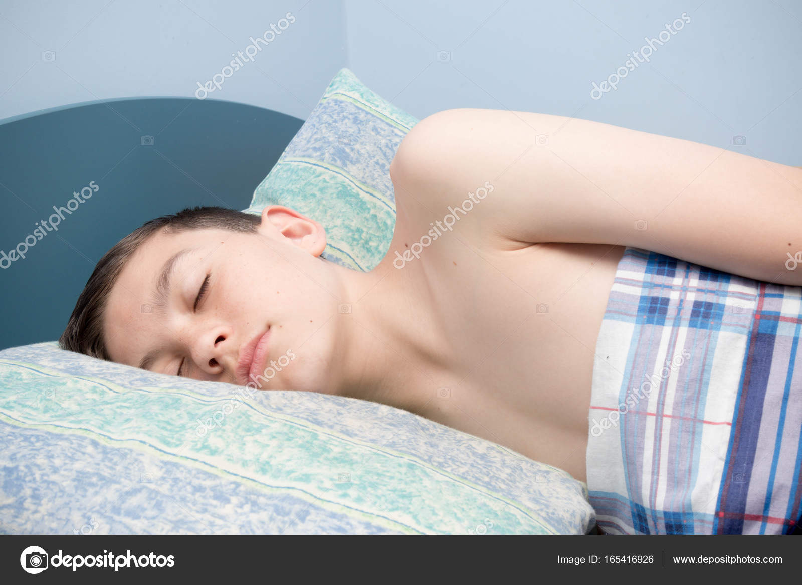 Teen boy waking up in a bed