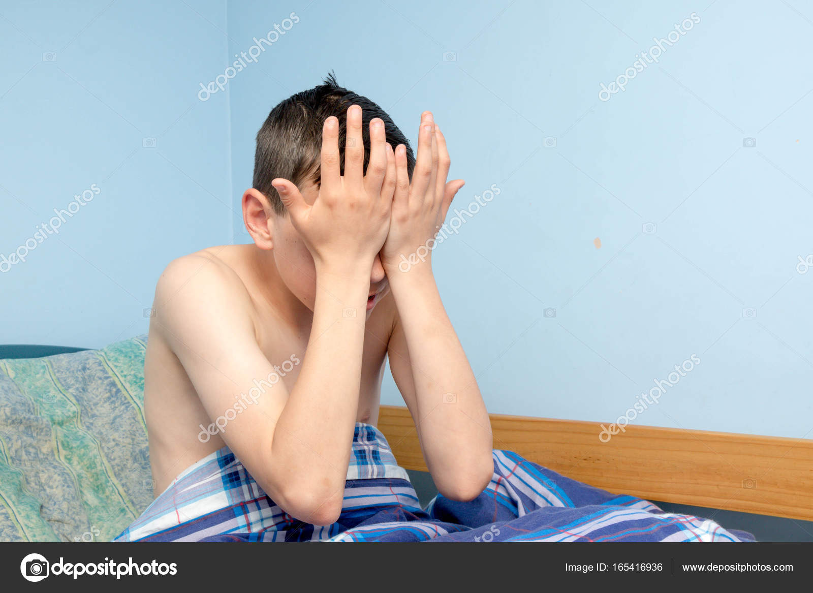 Teen boy waking up in a bed